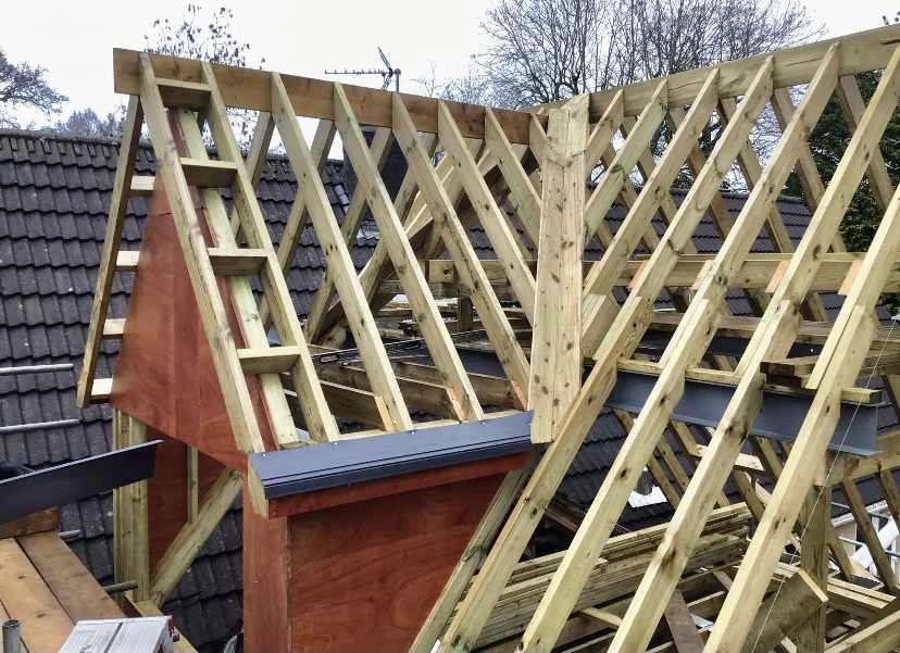 New roof trusses craned into position over an extension